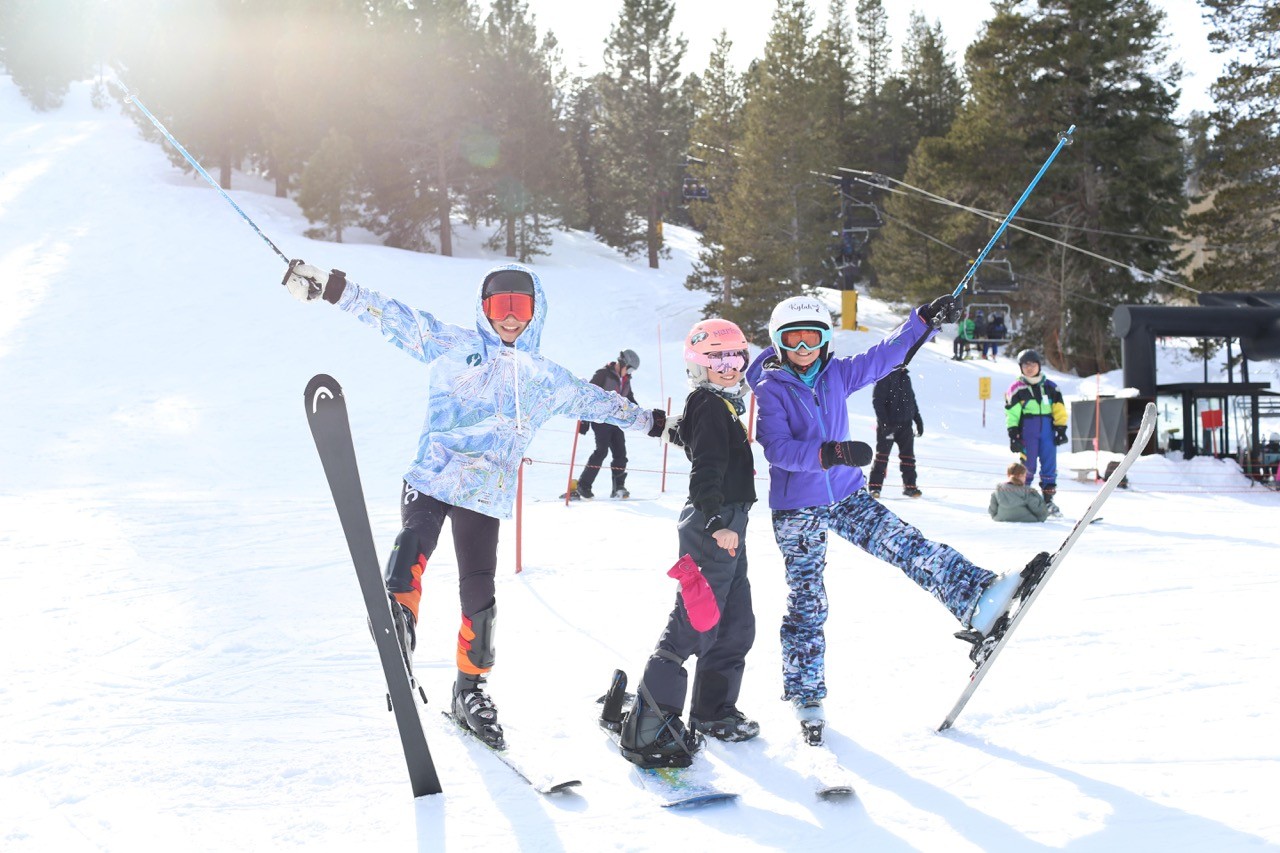 Happy skiers with poles in the air